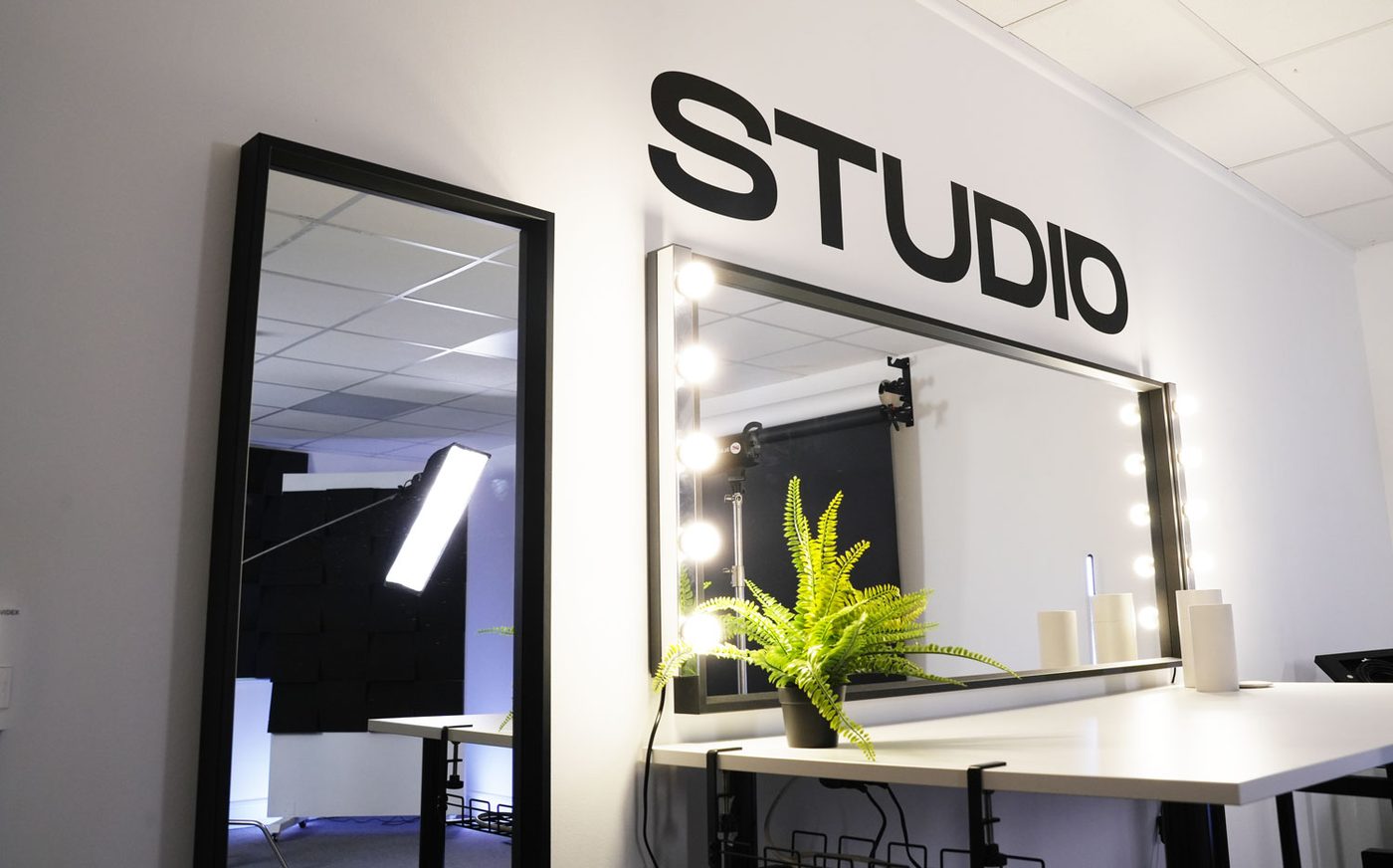 Mirror with bulb lighting and a director’s chair at the beauty station